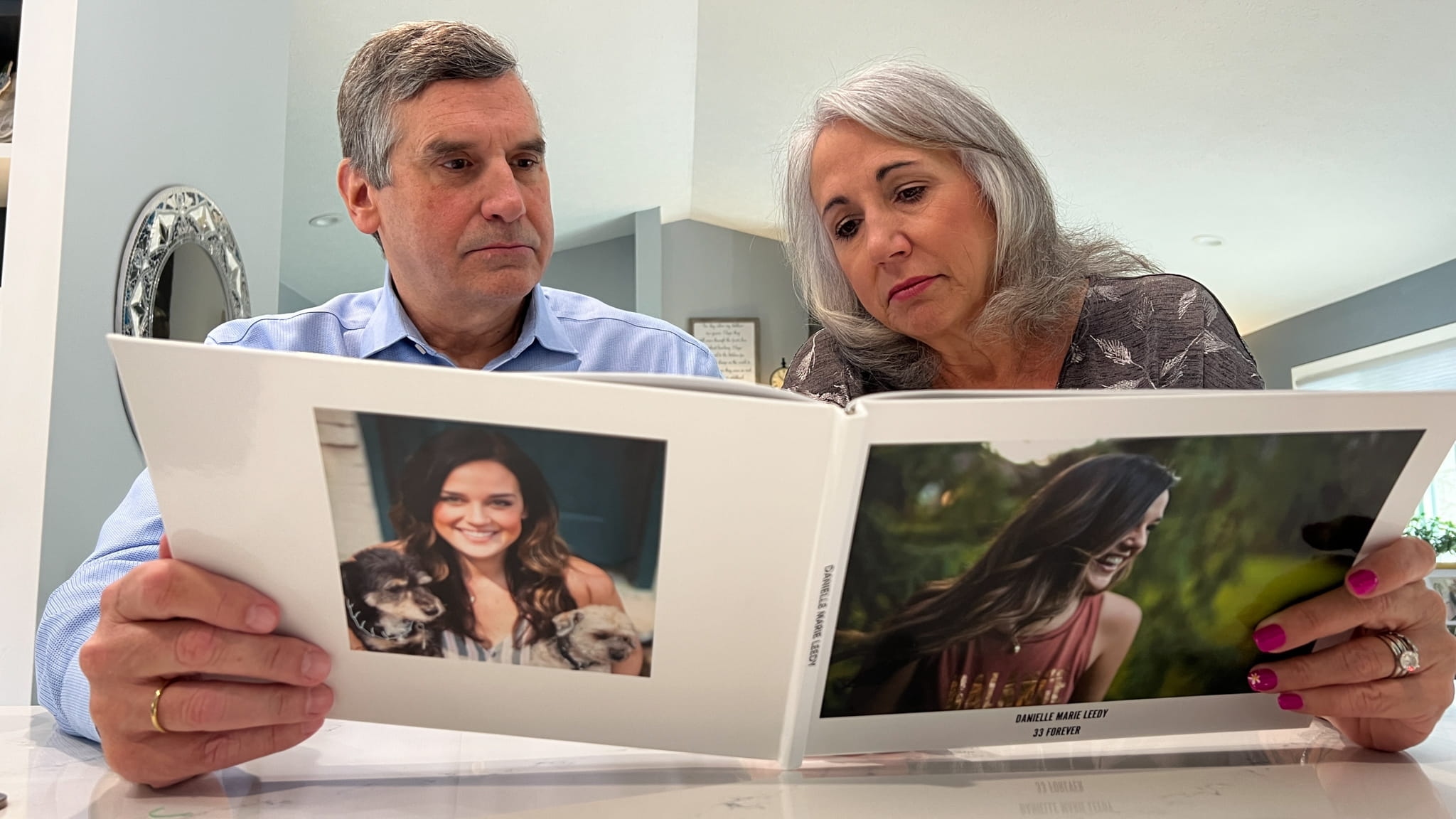 Jeff and Donna Heck look at a photo book of their daughter Dani, who died by suicide