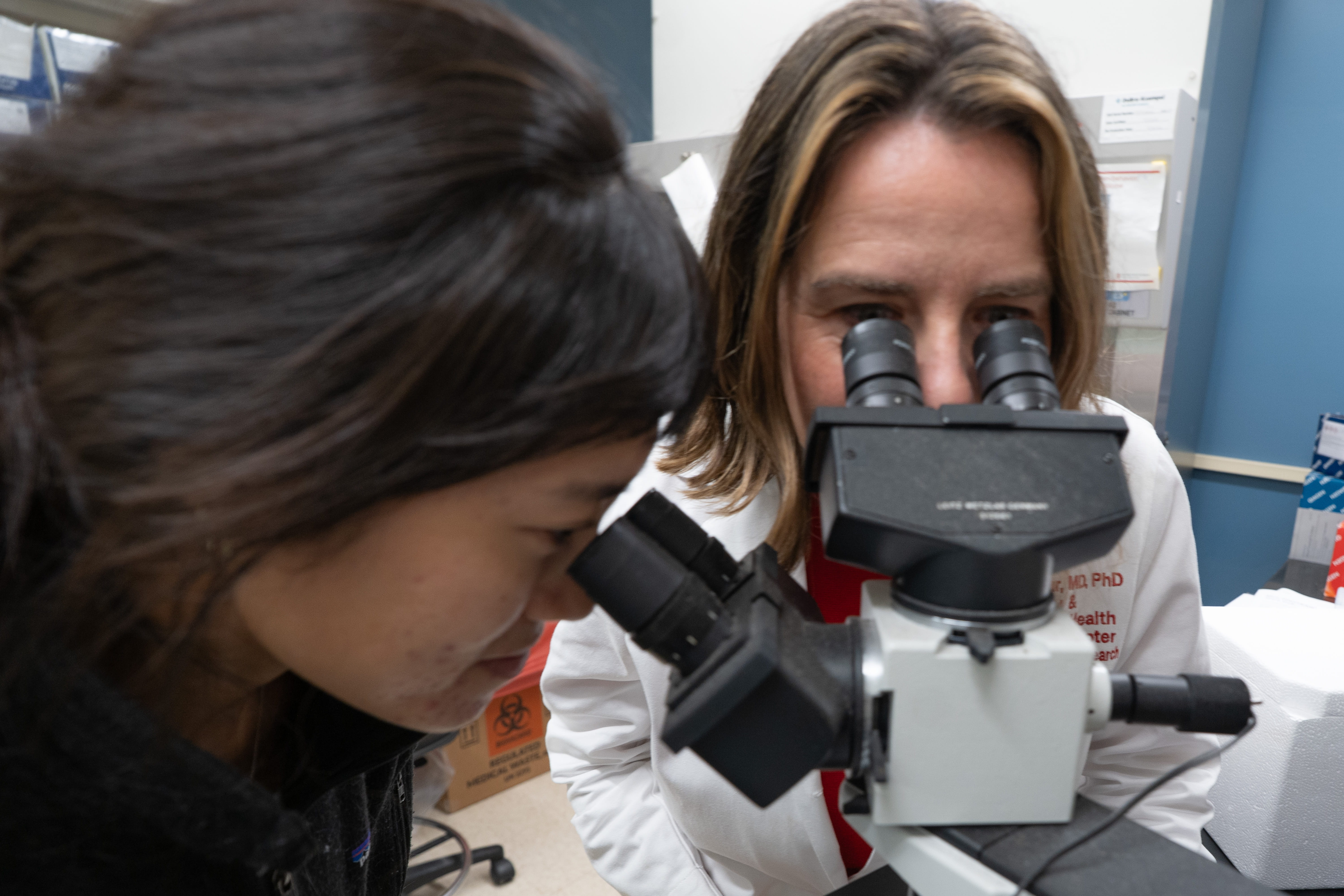 Tamar Gur, MD, PhD, (right) examines slides of a placenta under a microscope in her lab at The Ohio State University Wexner Medical Center in Columbus, Ohio.