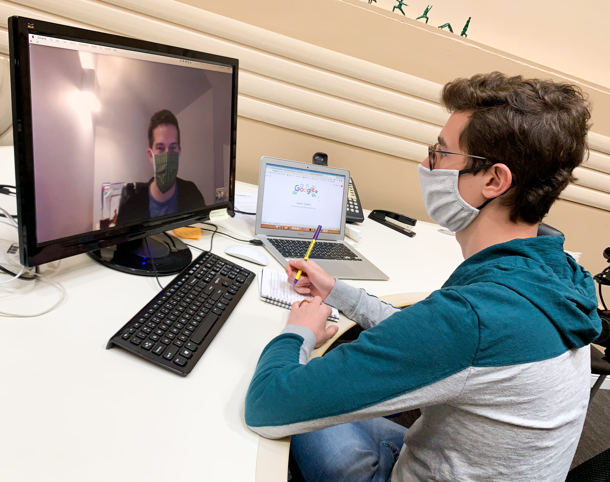Man wearing face mask while on video conference call at work