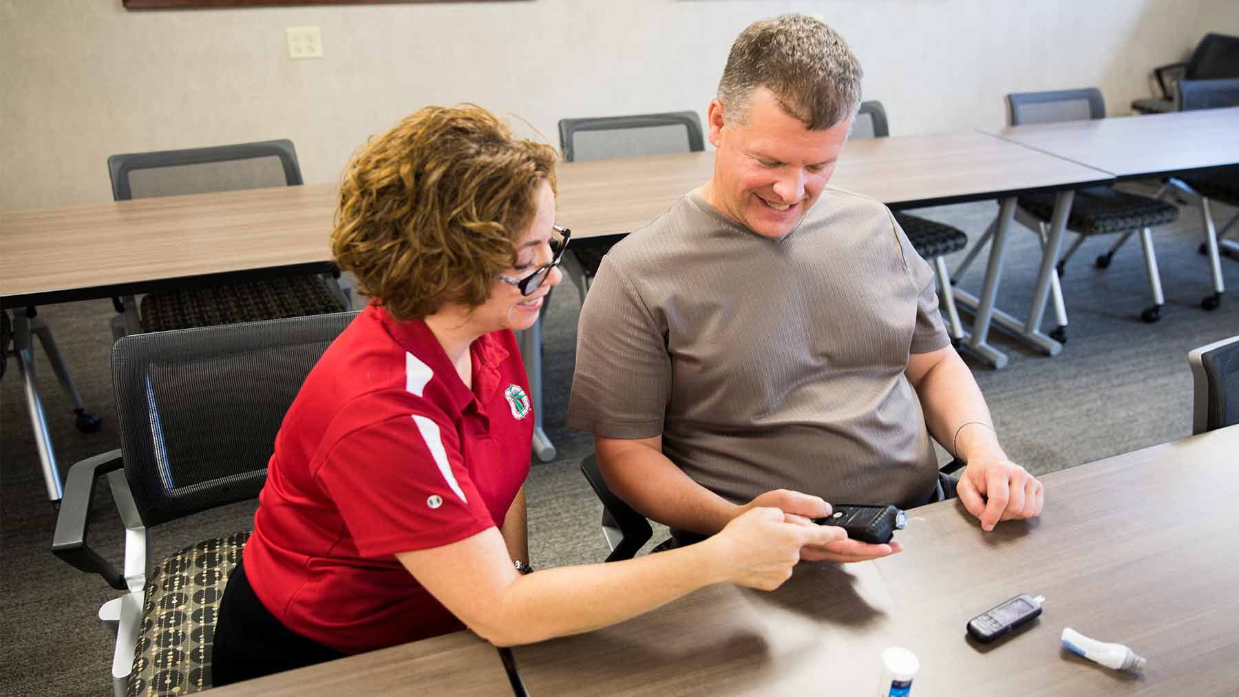 Ohio State's Janet Zappe shows Jeffrey Walline features of a new hybrid blood sugar monitor and insulin pump system.