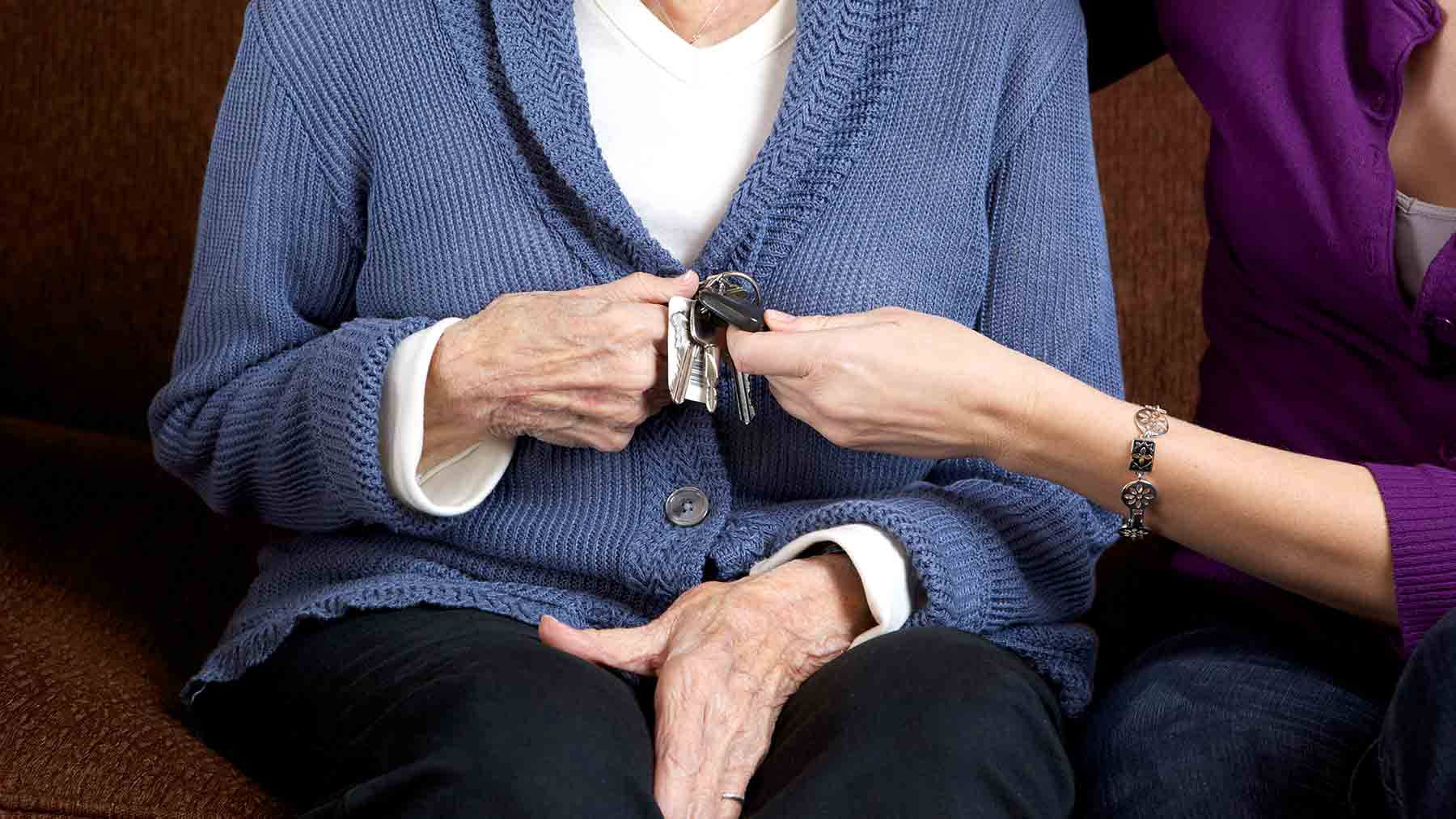 Younger woman taking car keys away from older woman