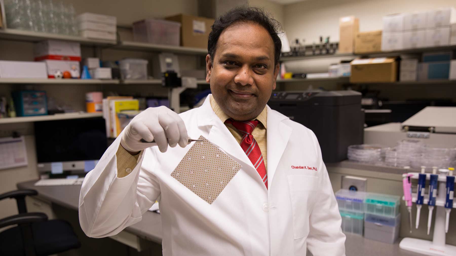 Chandan Sen, PhD, holds wireless electric bandage