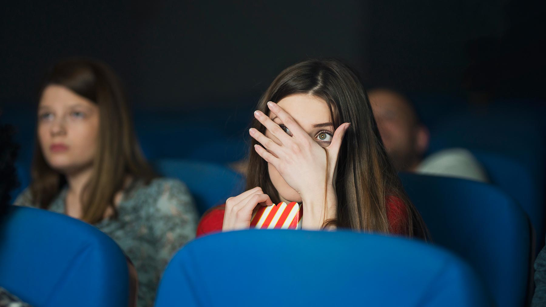 scared woman watching movie at a theater