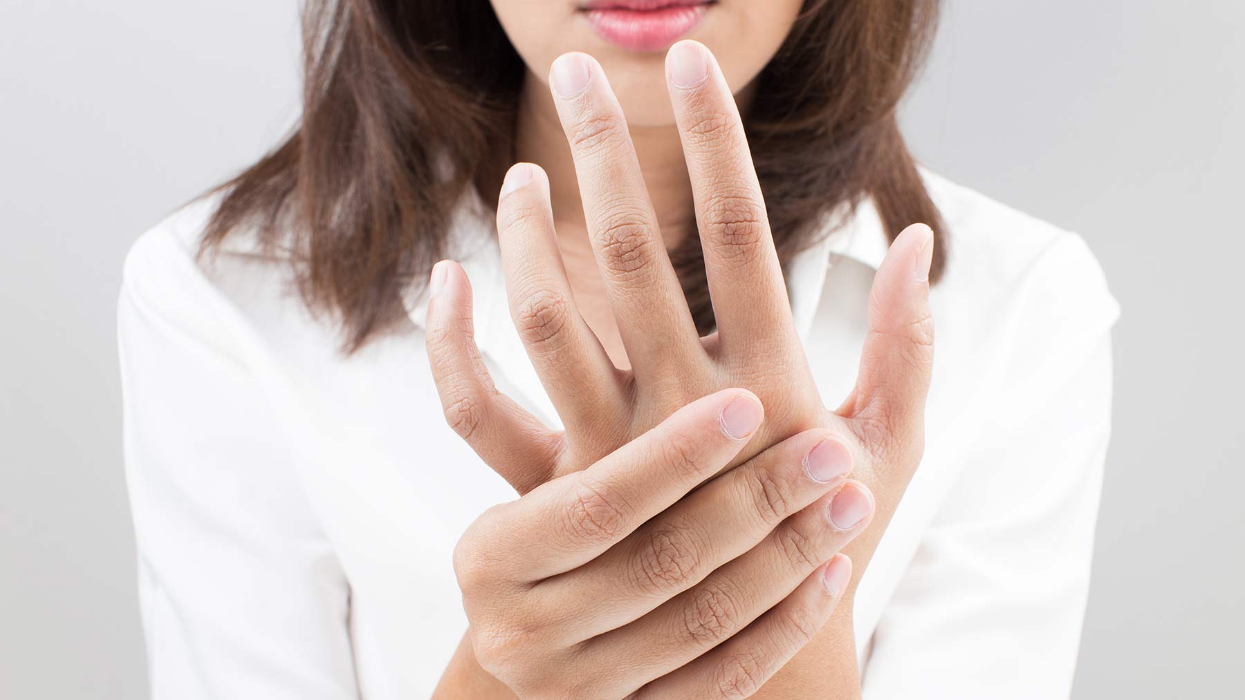 woman rubbing painful hand