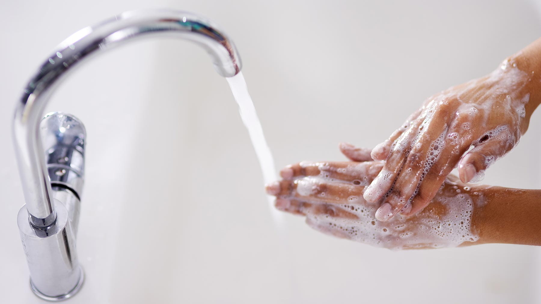 washing hands under faucet of running water