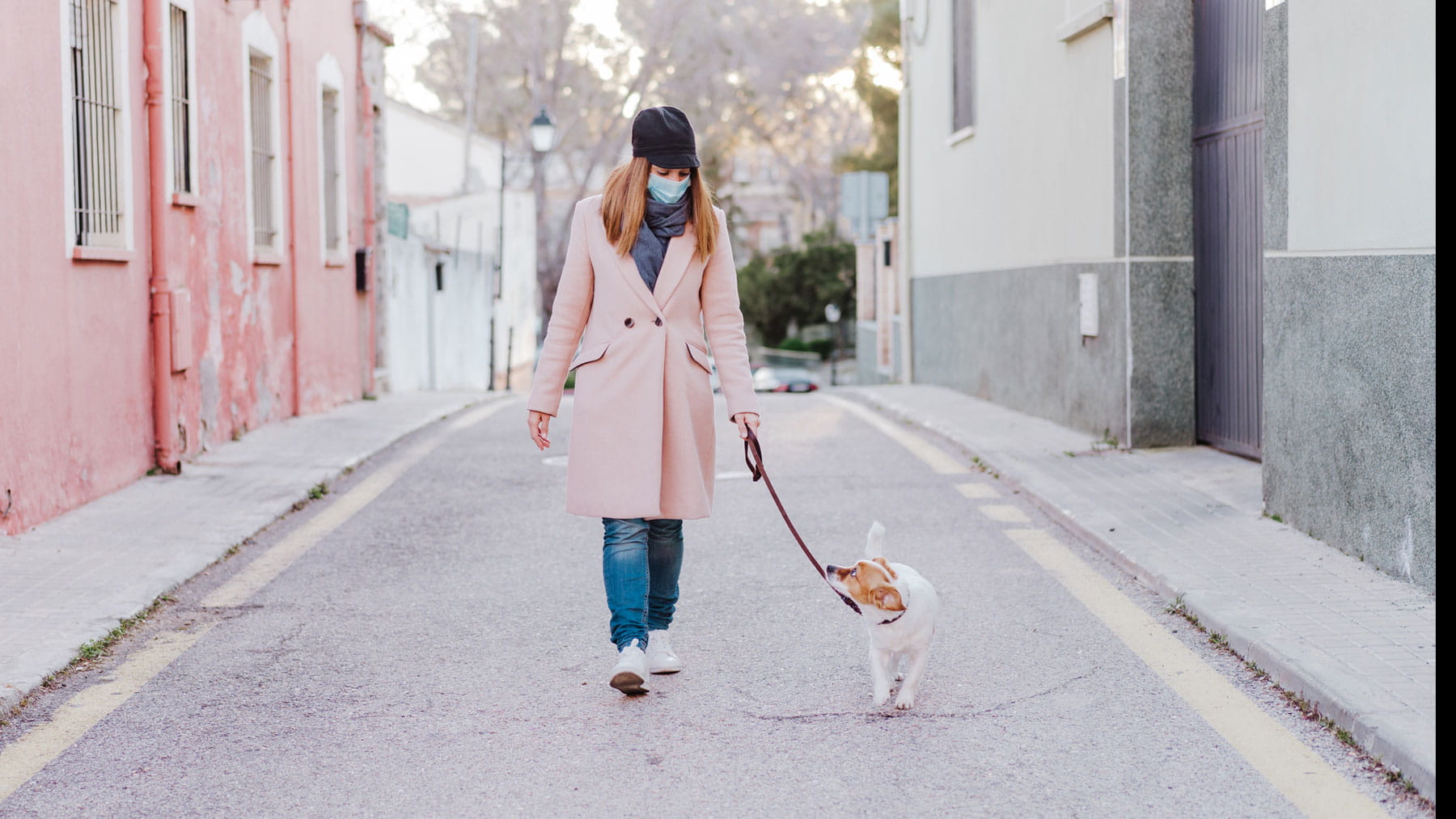 Woman wearing mask walks dog