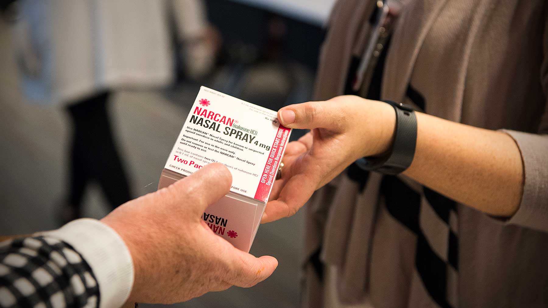 one person giving another person a Narcan kit