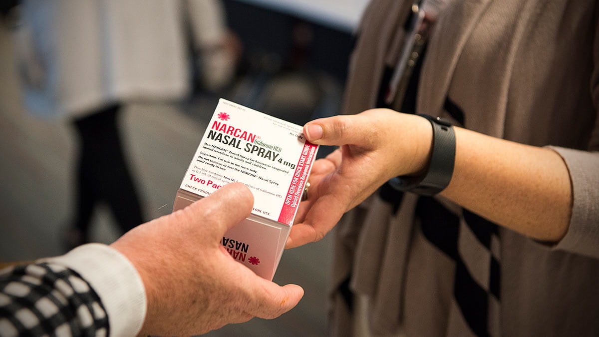 one person giving another person a Narcan kit