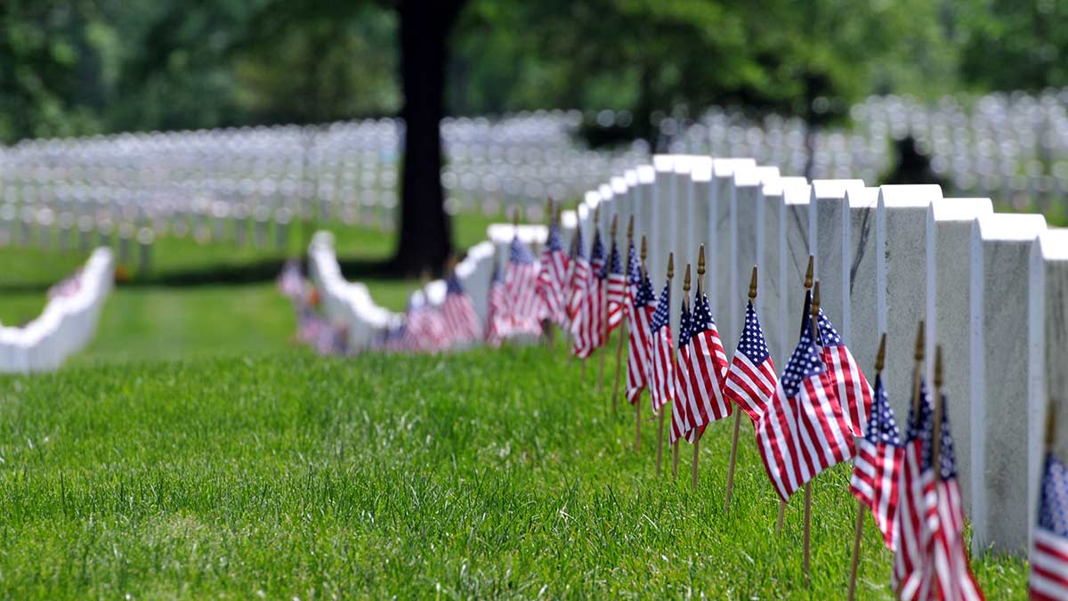 flags lined up along military tombstones