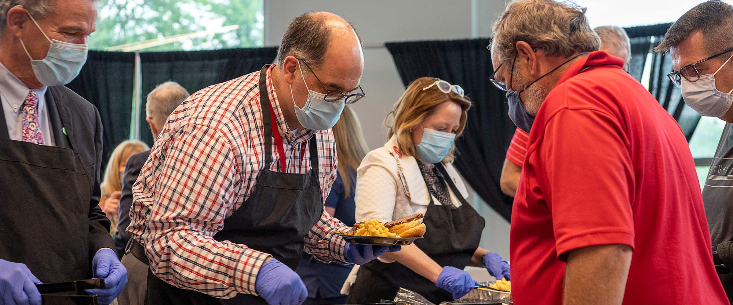 Andy Thomas serving food at a volunteer event