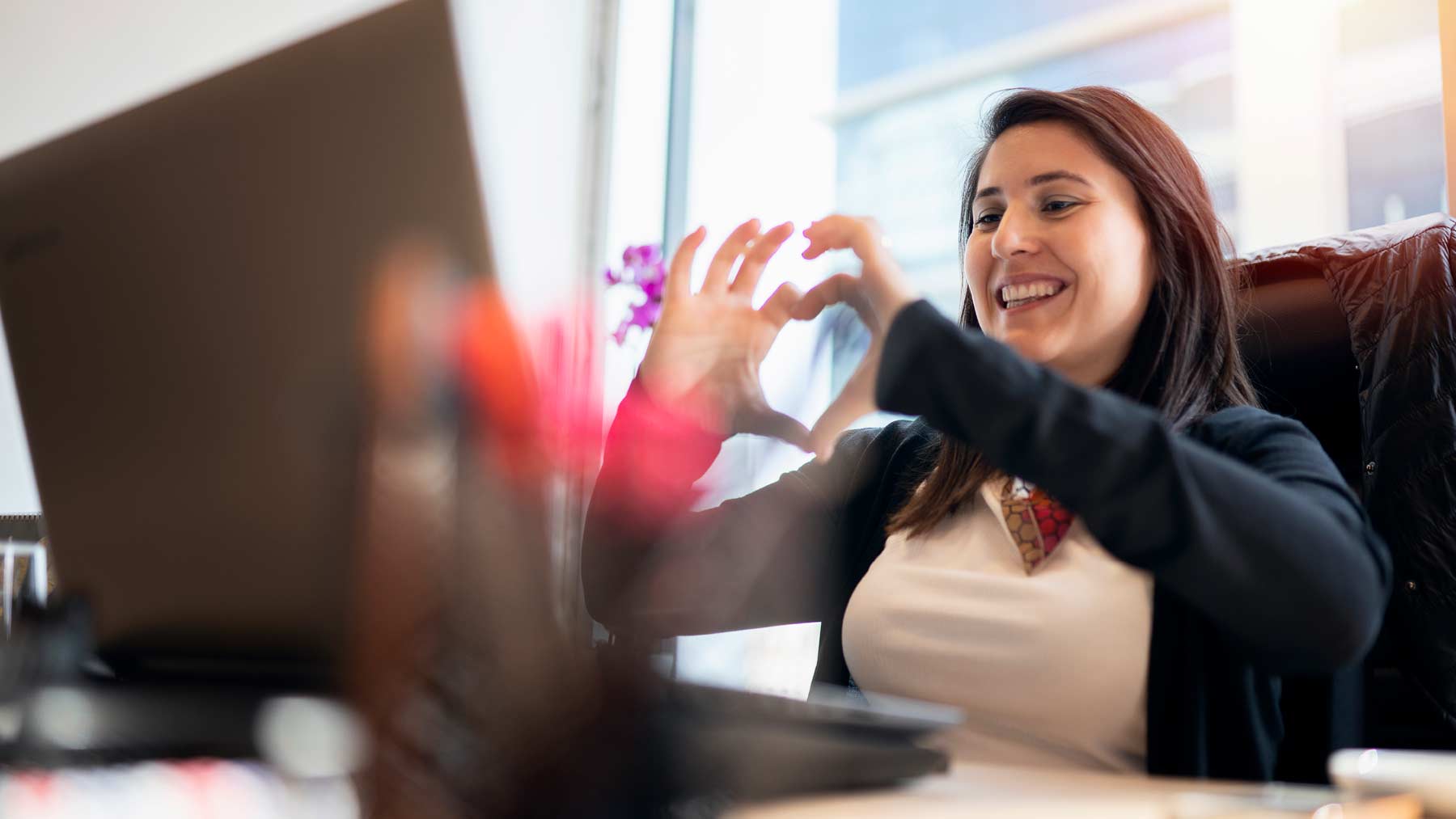 Woman on video chat with heart hands