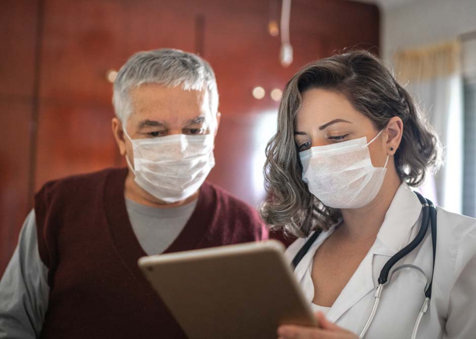 Doctor counseling patient both masked