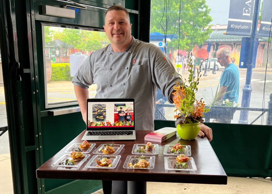 Chef David Brue in front of a table with tostones