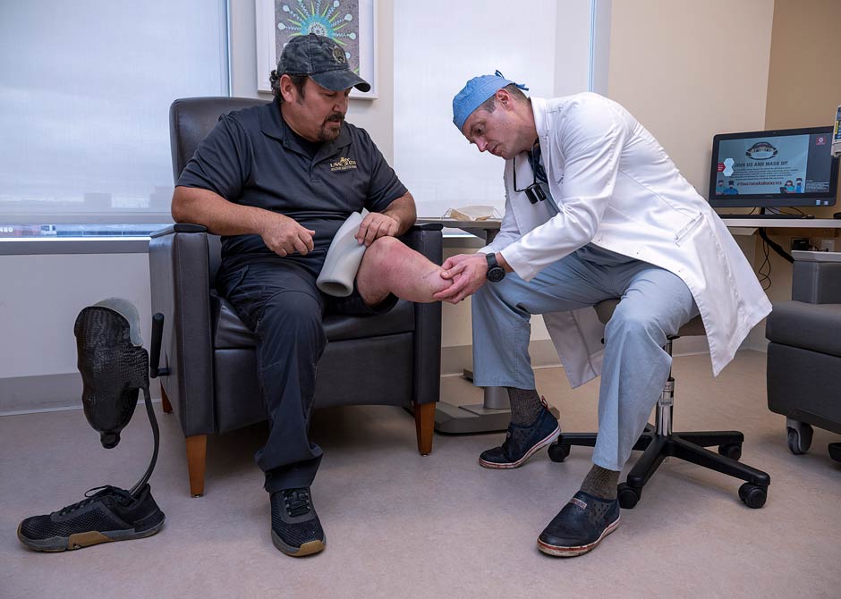 Dr. Souza assisting amputee patient with prosthetic
