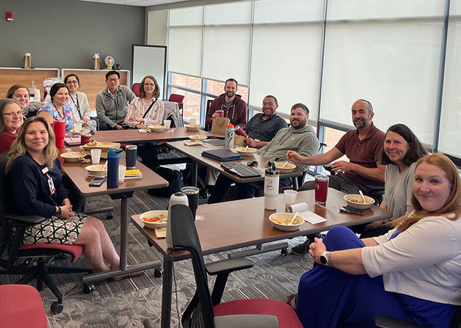 Ann Scheck McAlearney, ScD, MS; Jim Burke, MD, MS; and Lauren Teuschler, MEd, share a lunch in a meeting room with participants in the CATALYST Clinical Scholars Program.