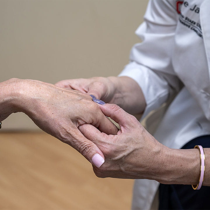A provider holding a patient's hand.