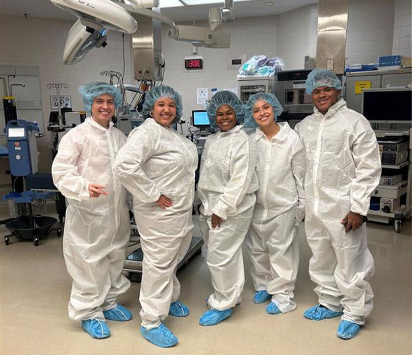 Group of interns smiling in OR shadow practice. 