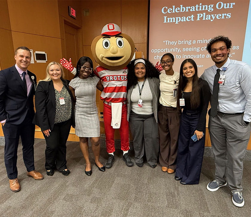 Group of interns smiling with Brutus Buckeye. 