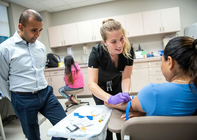 expanding access, child patient with friendly providers in an exam room