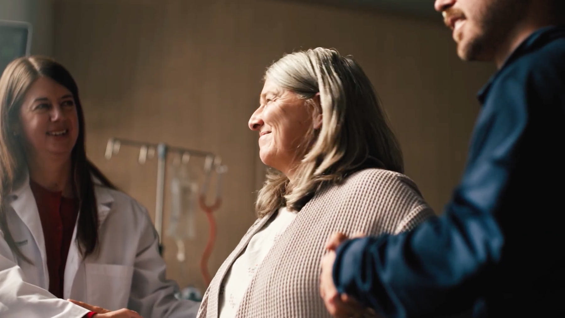 video screenshot showing a patient being assisted by a smiling doctor