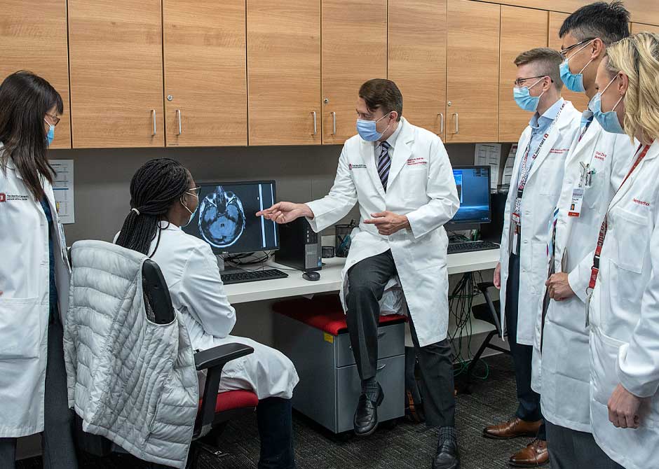 Neurology providers in lab reviewing monitor with brain scan