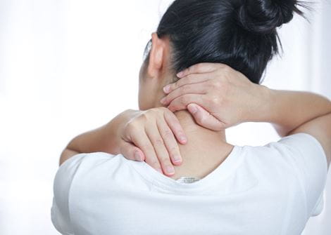 Woman with neck pain holding her neck