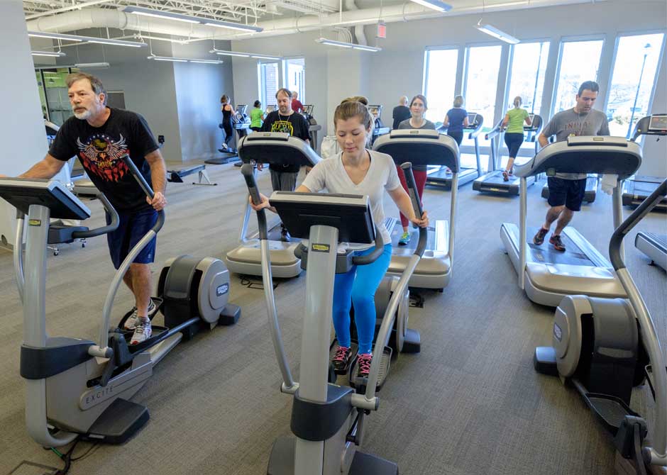 Group exercising on treadmills and ellipticals