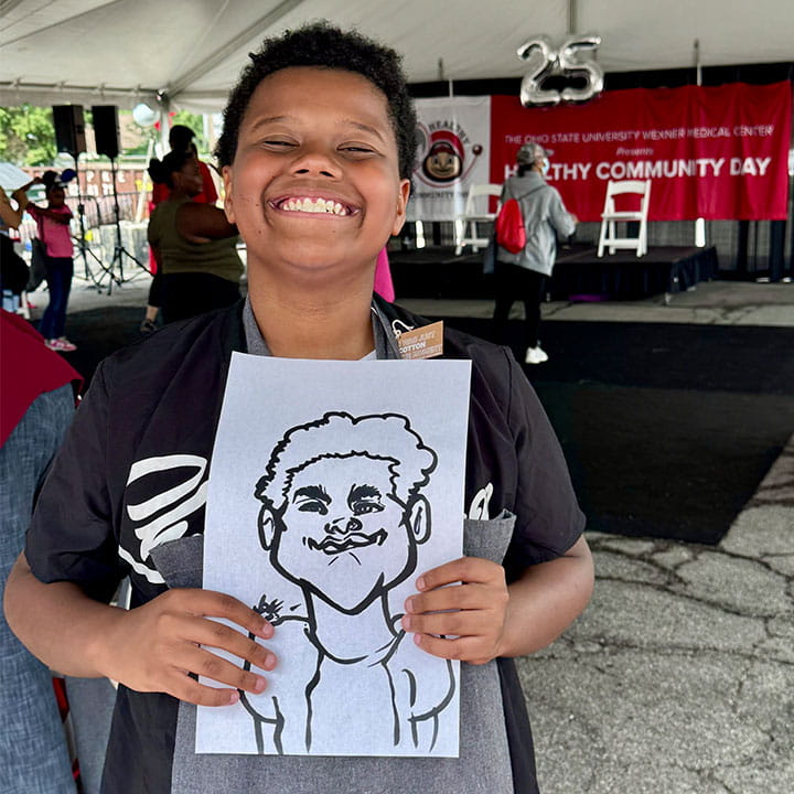 Kid holding a caricature illustration og himself. 