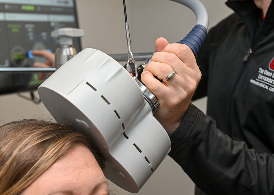 Transcranial Magnetic Stimulation (TMS) being performed on patient