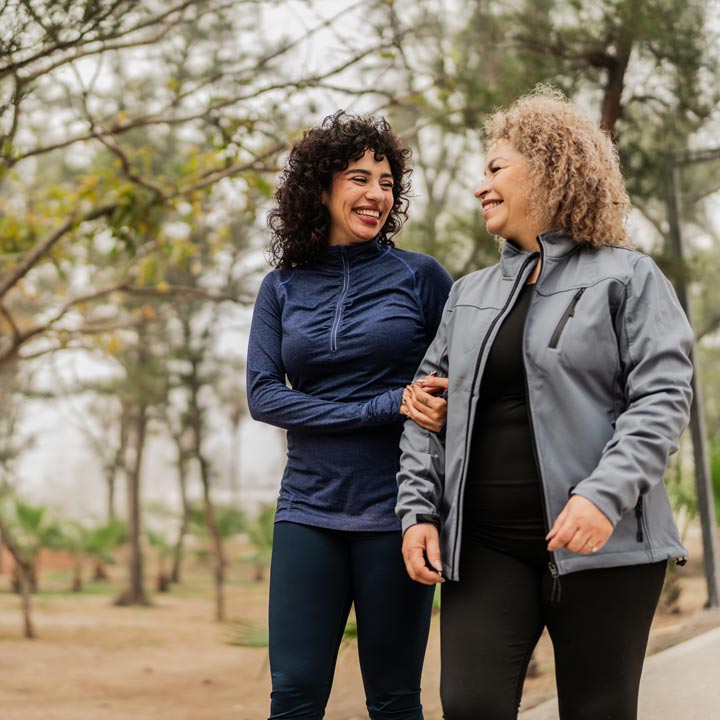 Mother-and-daughter-talking-while-walking-through-the-public-park