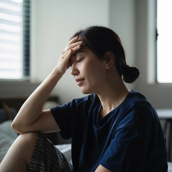 woman holding head with headache