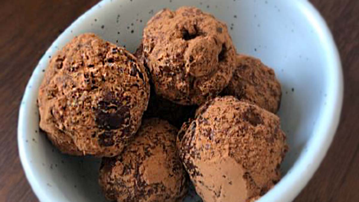 Five small chocolate dusted truffles in a bowl