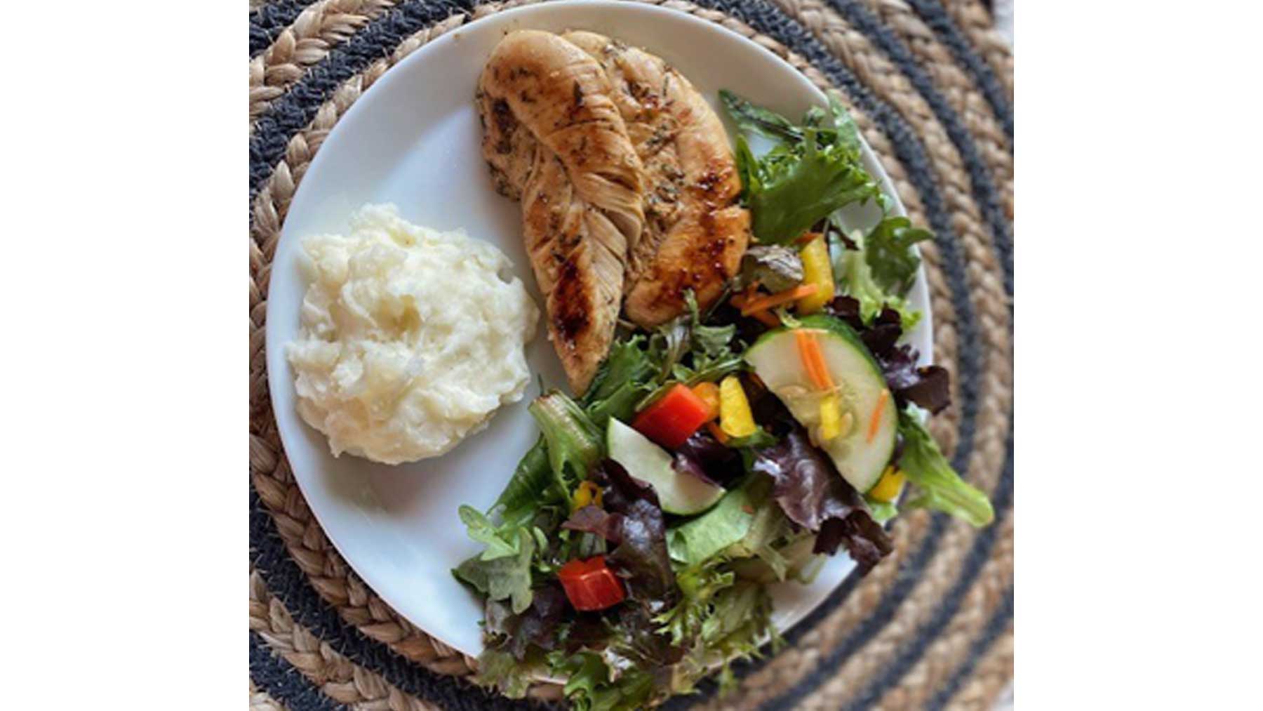 apple cider braised chicken tenders with mashed potatoes and a salad on a plate