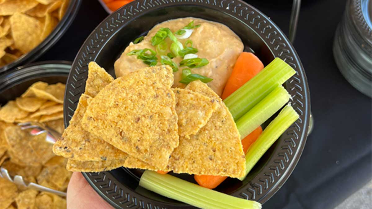 buffalo white bean dip, chips, and vegetables on a plate