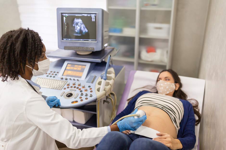 Sonographer gives ultrasound to pregnant woman