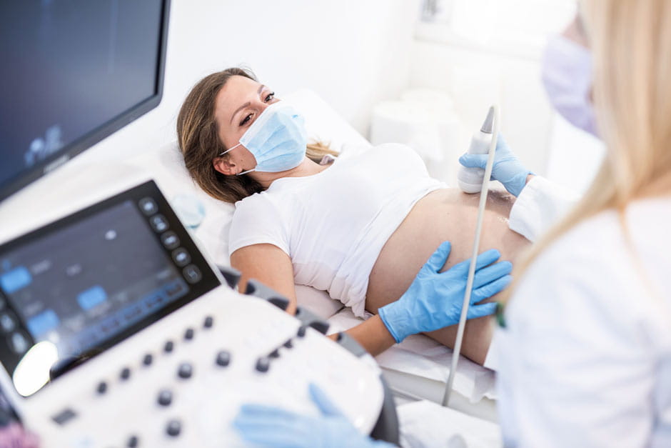 Pregnant woman receives ultrasound from sonographer
