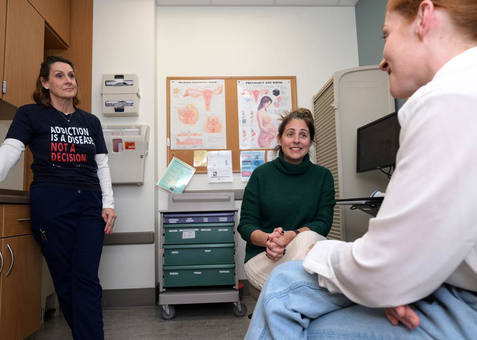 providers talking to pregnant woman in exam room