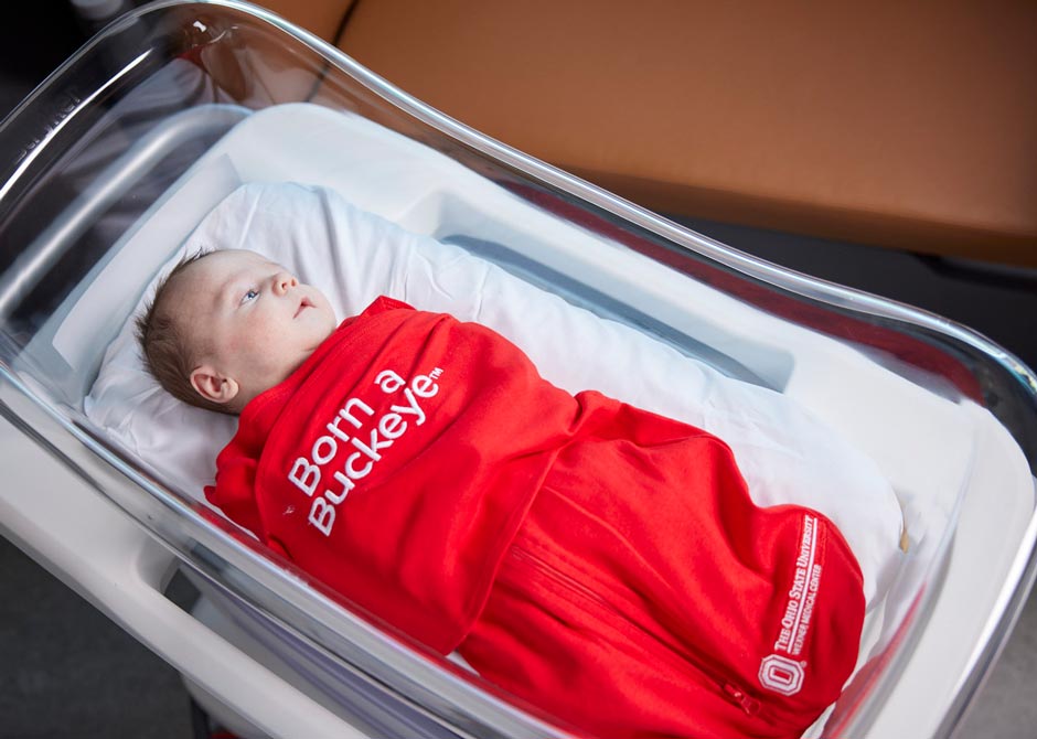 newborn baby swaddled in blanket that says "beat Michigan"