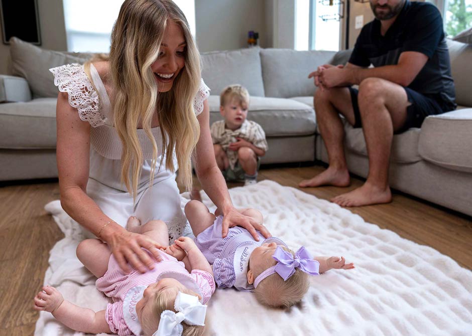mom and dad playing with their twin babies on the floor