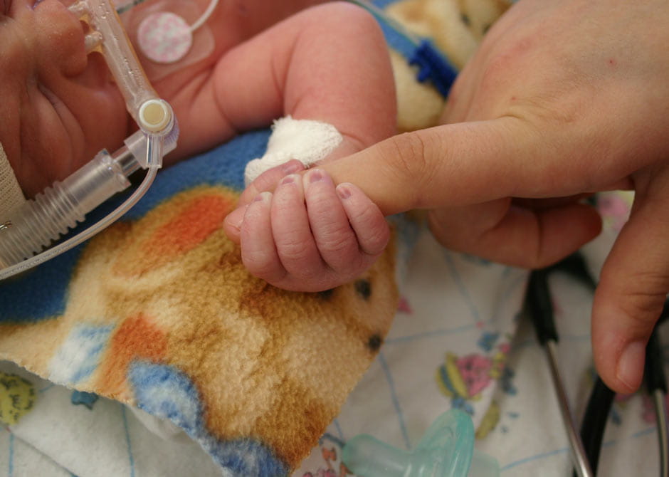 premature baby holding parents finger