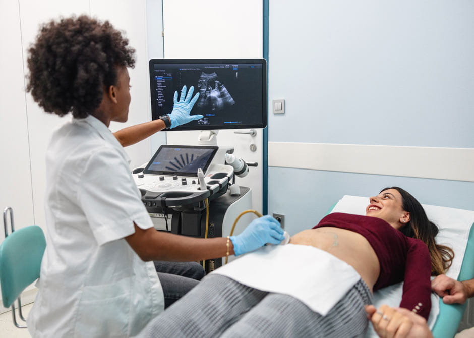 Sonographer gives ultrasound to pregnant woman