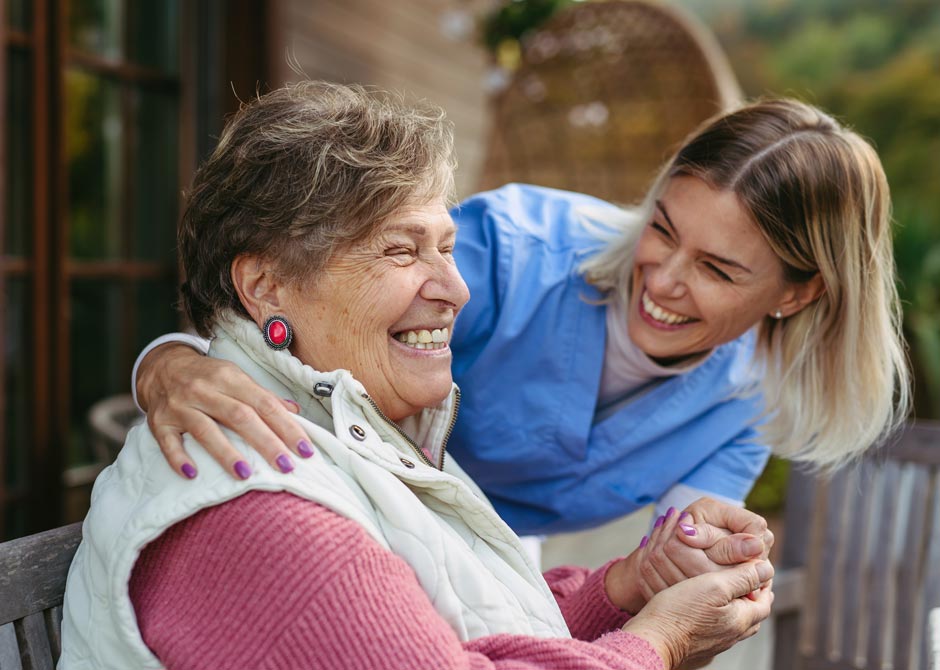 elderly care patient with nurse smiling