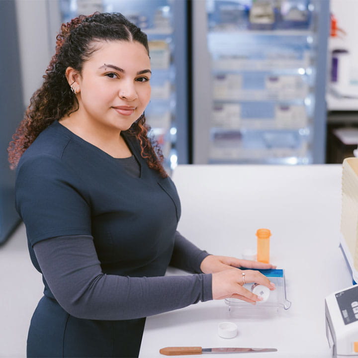 Woman holding tool in pharmacy.