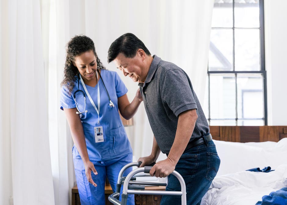 nurse helping a man with a walker out of bed