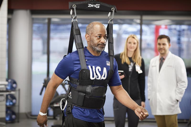 man using assistive walking device in therapy