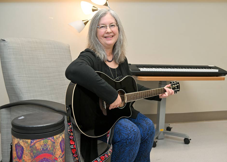 woman playing a guitar and smiling
