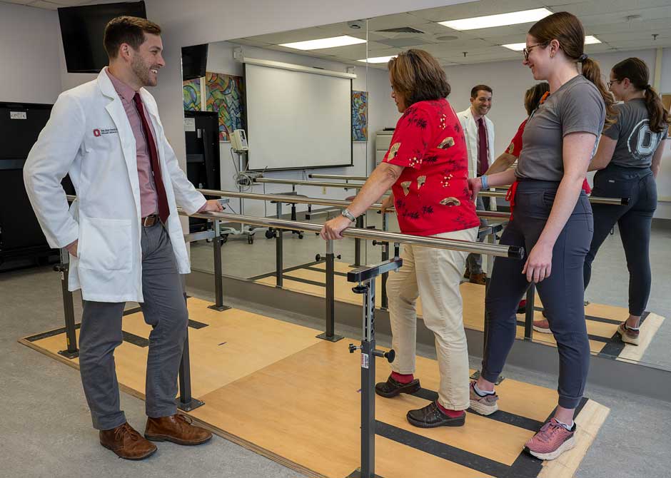 Dr. Hake and a physical therapist help a patient learn to walk again