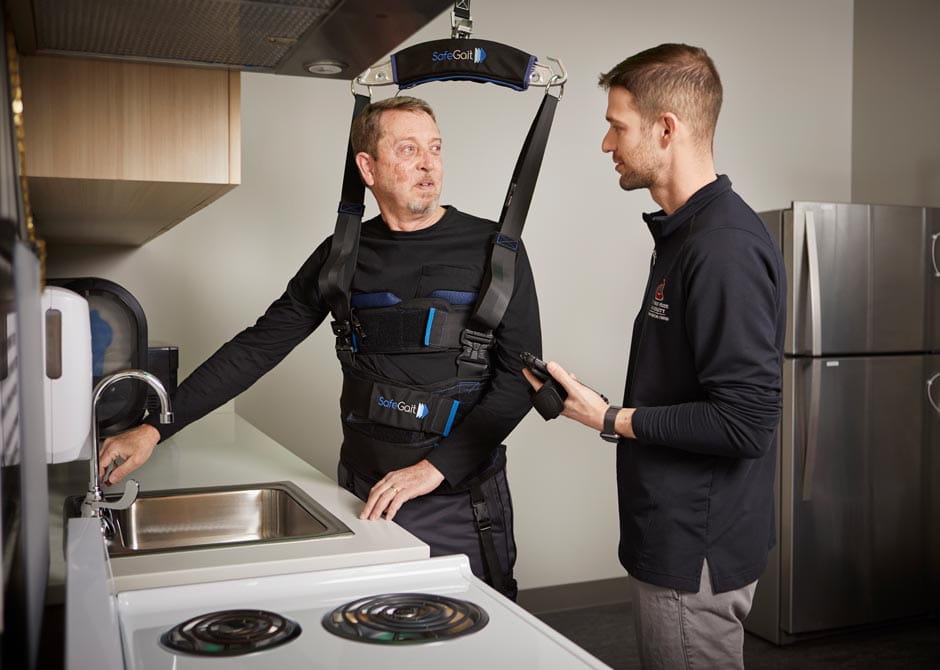 A man practicing moving around a kitchen during his inpatient rehabilitation at Dodd Hospital