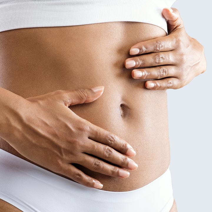 Woman with her hands resting on her toned stomach