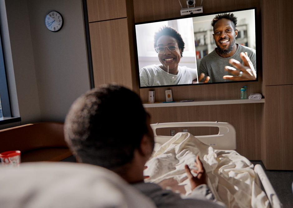 Patient in bed talking over webcam with family.jpg